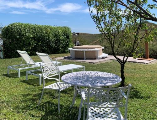 a group of chairs and a table in the grass at TulipHouse - Apartment Ballerina in Vezza d'Alba