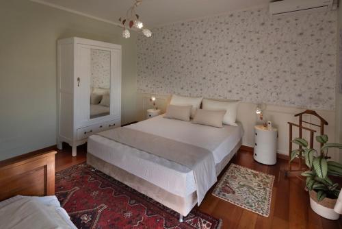 a bedroom with a large white bed and a rug at TulipHouse - Apartment Ballerina in Vezza d'Alba