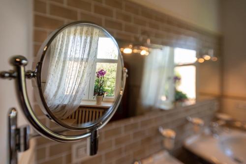 a mirror in a bathroom with a sink and a window at TulipHouse - Apartment Ballerina in Vezza d'Alba