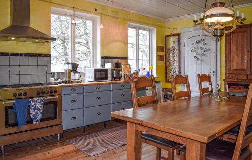 a kitchen with a wooden table and a wooden dining table at Beautiful Home In Smedstorp With Wifi in Smedstorp