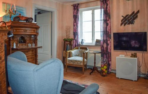 a living room with a blue chair and a tv at Beautiful Home In Smedstorp With Wifi in Smedstorp