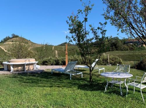 a table and chairs in a yard with a hot tub at TulipHouse - Apartment Ballerina in Vezza d'Alba