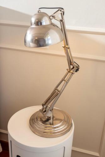 a silver lamp sitting on top of a toilet at TulipHouse - Apartment Ballerina in Vezza d'Alba