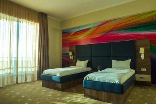 two beds in a room with a painting on the wall at Castello Mare Hotel in K'obulet'i