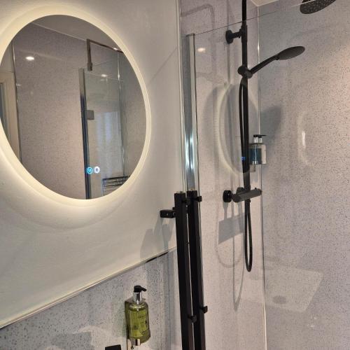 a bathroom with a shower with a mirror at Kintrae B&B in Buckie