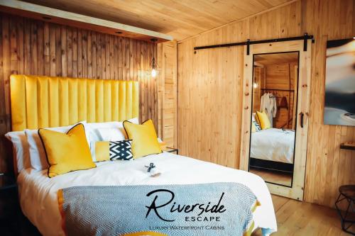 a bedroom with a large bed with yellow pillows at Riverside Escape in Secunda