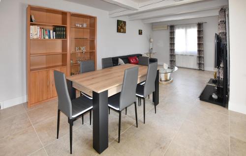 une salle à manger avec une table et des chaises en bois dans l'établissement 2 Bedroom Stunning Home In Sarrians, à Sarrians