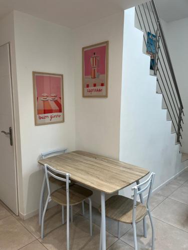 une table et des chaises dans une pièce avec un escalier dans l'établissement Superbe Appartement Redon, à Marseille