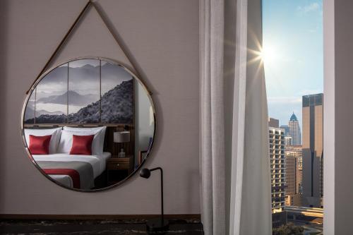 a mirror in a room with a bed and a window at Grand Millennium Business Bay in Dubai