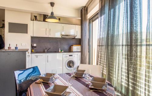 une cuisine avec une table et des chaises ainsi qu'un lave-linge. dans l'établissement 1 Bedroom Cozy Apartment In La Rochelle, à La Rochelle