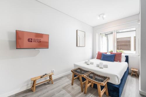 a bedroom with a bed and a tv on a wall at GuestReady - Homely stay in Porto in Porto