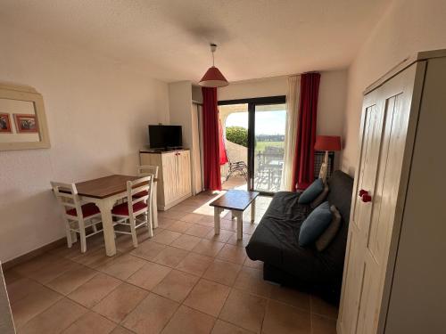 un salon avec un canapé et une table dans l'établissement Appartement - place de parking - terrasse vue mer, à Saintes-Maries-de-la-Mer