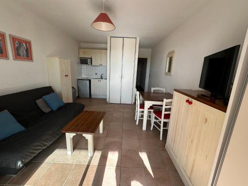 un salon avec un canapé et une table dans l'établissement Appartement - place de parking - terrasse vue mer, à Saintes-Maries-de-la-Mer