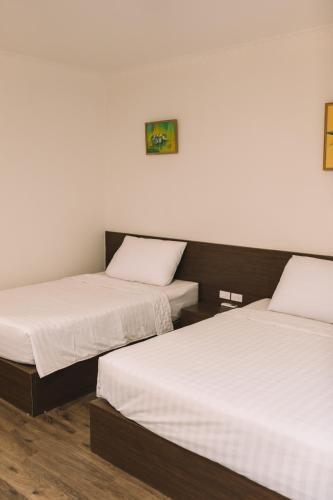 two beds in a room with white sheets at Tamcoc TK Hotel & Homestay in Ninh Binh