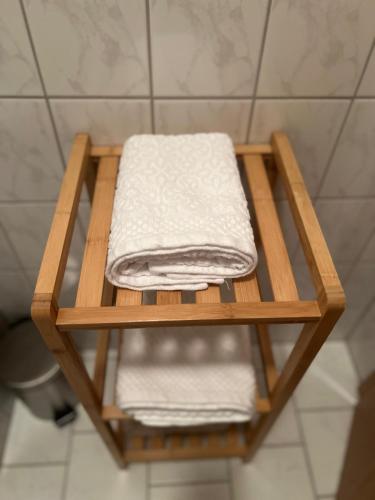 a wooden shelf with towels on it in a bathroom at Olymp Hotel in Magdeburg