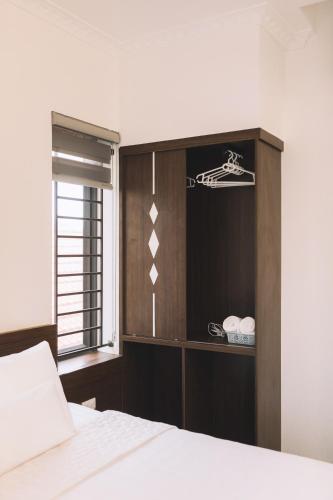 a bedroom with a bed and a wooden cabinet at Tamcoc TK Hotel & Homestay in Ninh Binh