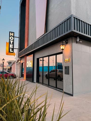 a building with glass doors with a car in it at OLLÁ HOTEL Montes Claros in Montes Claros