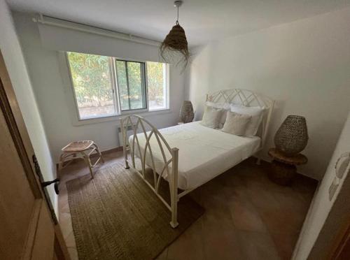 une chambre avec un lit blanc et une fenêtre dans l'établissement Villa Les Roches, à La Croix-Valmer