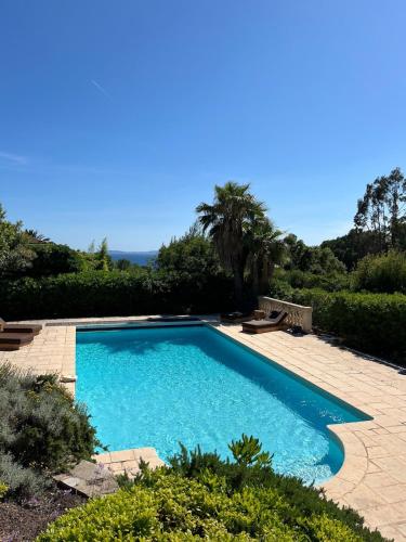 une piscine avec de l'eau bleue dans une cour dans l'établissement Villa Les Roches, à La Croix-Valmer