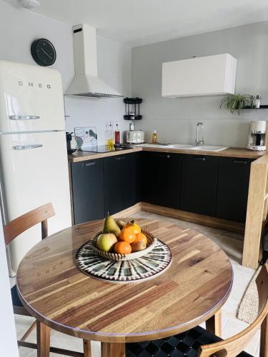 a bowl of fruit on a wooden table in a kitchen at Les Arches du Lac, spa et piscine intérieure chauffée in Saint-Martin-lès-Langres