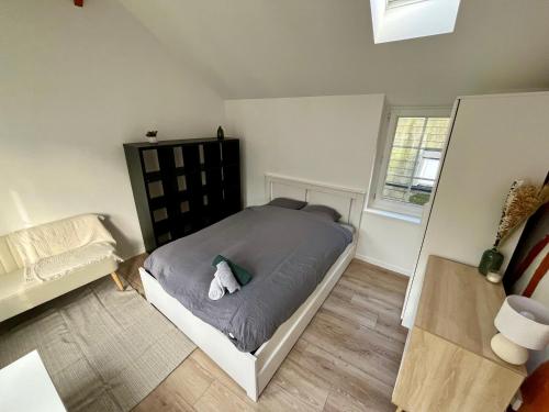 une chambre avec un lit avec un animal en peluche dessus dans l'établissement Au rythme des saisons - 364, à Rouen