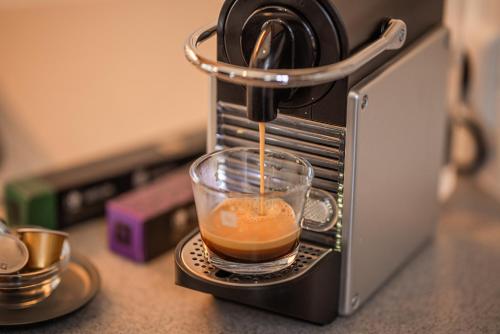 a cup of coffee is being poured into a toaster oven at Alpine Spa Residence in Bad Kleinkirchheim