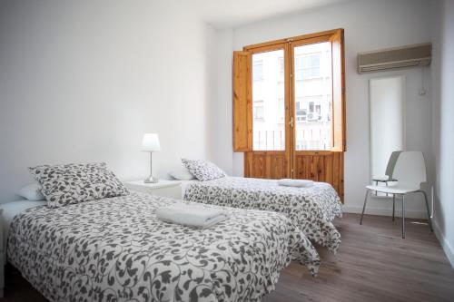 sypialnia z dwoma łóżkami i oknem w obiekcie Fuencarral Apartments w Madrycie