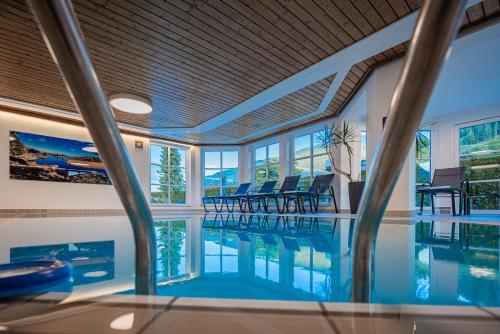 a swimming pool with chairs in a house at Alpine Spa Residence in Bad Kleinkirchheim