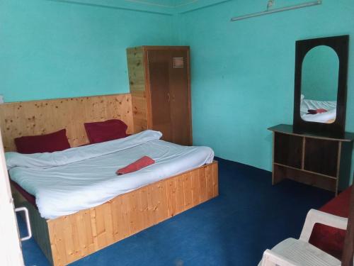 a bedroom with a large bed with a mirror at Apple Field House in Manāli