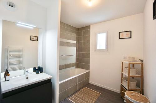 une salle de bain avec une baignoire et un lavabo dans l'établissement L'horizon -parking, à Concarneau
