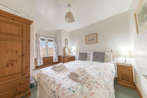 a bedroom with a bed with towels on it at Rose Bank Cottage Coniston in Coniston