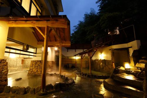 a building with a water fountain in a courtyard at night at Hakone Kamon in Hakone