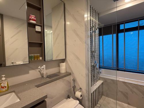 un bagno con un water, un lavandino e uno specchio di Eaton Premier Suite KLCC a Kuala Lumpur