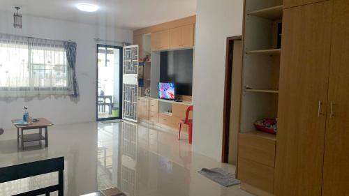 a large living room with a television and a table at Min&Me House Pattaya in Nong Prue