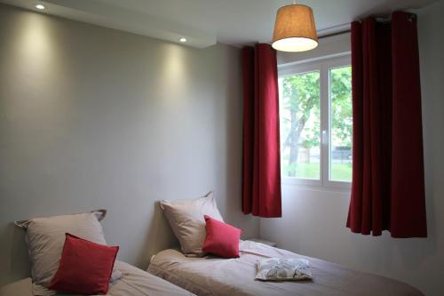 - une chambre avec 2 lits avec des rideaux rouges et une fenêtre dans l'établissement Fromentin - Parking - calme - proche port, à Vannes