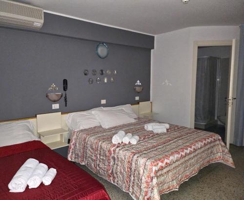 a hotel room with two beds with towels on them at Hotel Villa Rosa in Misano Adriatico