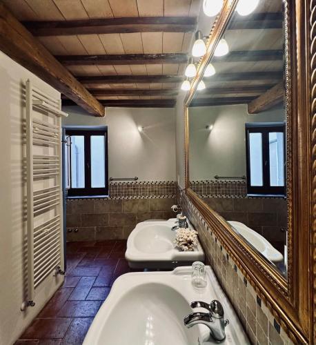 a bathroom with two sinks and a large mirror at Santa Monaca Medieval Guesthouse in Sorano