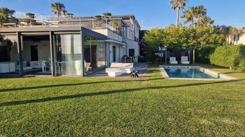 un chien marchant devant une maison dans l'établissement Maison-Appartement La Palmeraie piscine et magnifique vue mer, à Sanary-sur-Mer