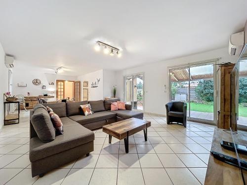 un salon avec un canapé et une table dans l'établissement La Flemme en Rose- Villa avec piscine-Pet Friendly, à Peyriac-de-Mer