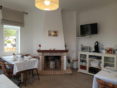 a living room with a table and a fireplace at VILLA L'ESTAQUE in Armação de Pêra
