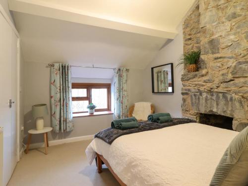 una camera da letto con un letto e un muro di pietra di Gwynfa a Betws-y-coed
