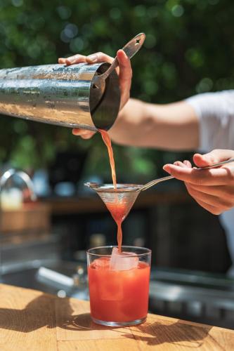 a person pouring a drink from a juicer into a cocktail at Yazz Collective in Fethiye