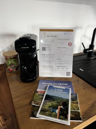 a magazine sitting on a table next to a coffee maker at Nouveau ! Chalet en centre ville in Bourg-en-Bresse