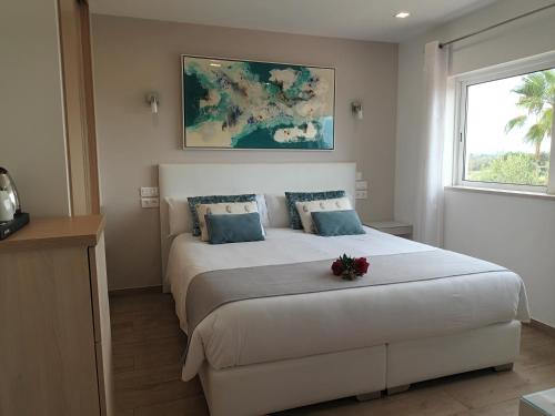 a bedroom with a large bed with a flower on it at VILLA L'ESTAQUE in Armação de Pêra