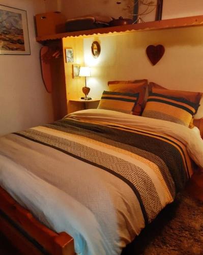 une chambre avec un grand lit avec une tête de lit en bois dans l'établissement LES LAIX - Chaleureux appartement 5 pers - Proche La Rosière, à Montvalezan