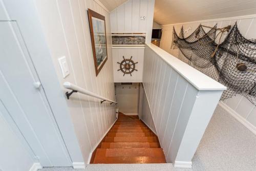 a hallway with a staircase with white walls and wooden floors at Sq Urban Retreat in Sequim