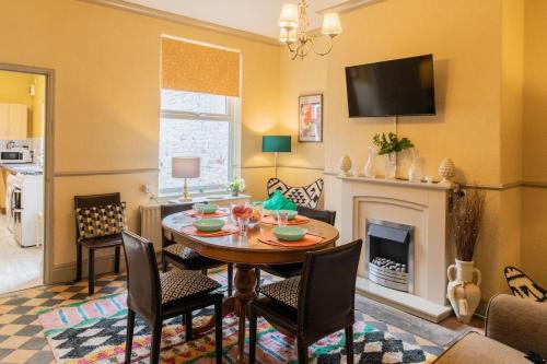 a living room with a table and a fireplace at No 2 Townhouse in Bishop Auckland