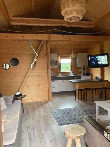 a living room of a log cabin with a television at Domki na Łące in Ostrów Pieckowski