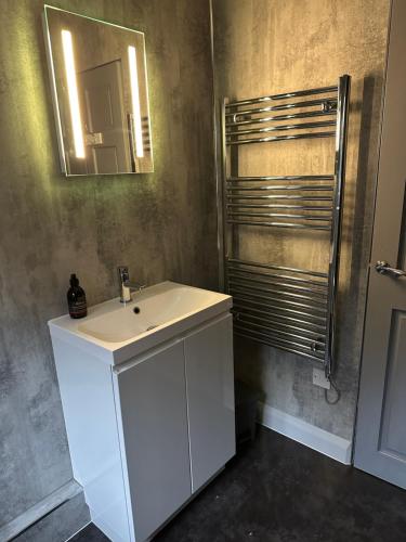 a bathroom with a white sink and a mirror at Burnside in Oban