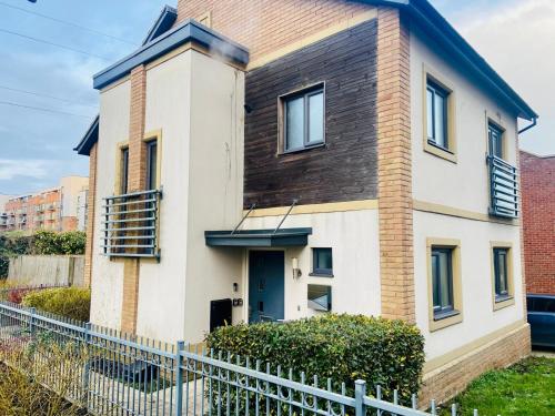 a house with a fence in front of it at Hawksbill 3 Bed Detached house with private parking in Peterborough